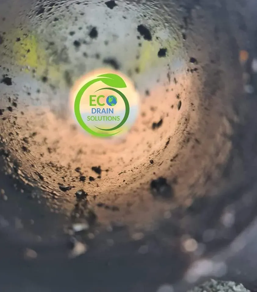 Eco Drain Solutions logo visible inside a dirty, gritty drain pipe during a professional CCTV inspection.