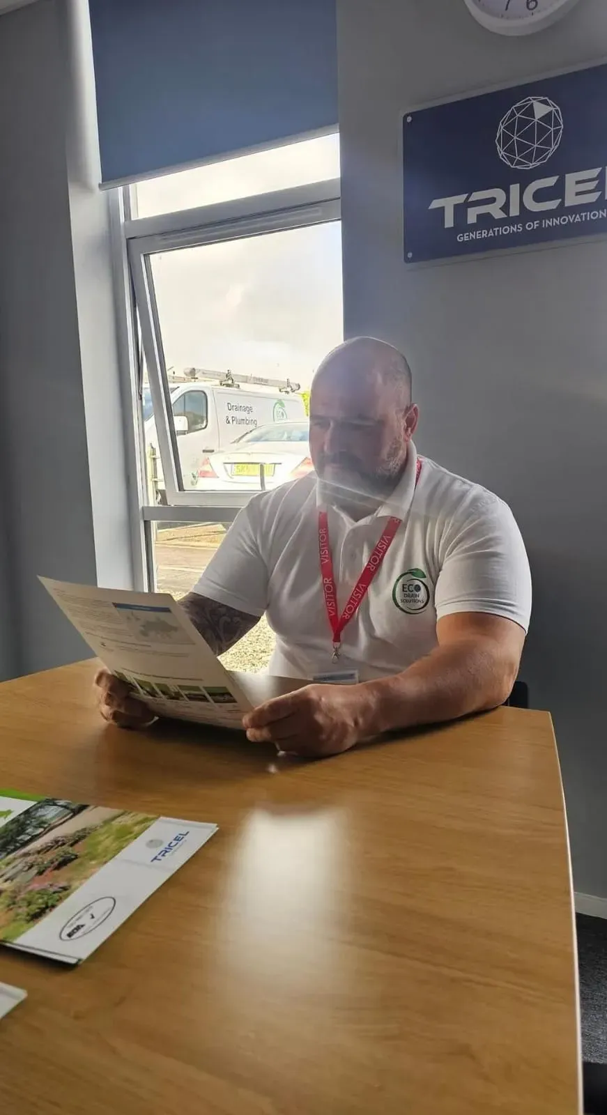 Eco Drain Solutions team member reviewing Tricel literature, demonstrating expertise in septic tank and sewage treatment plant installation and services.